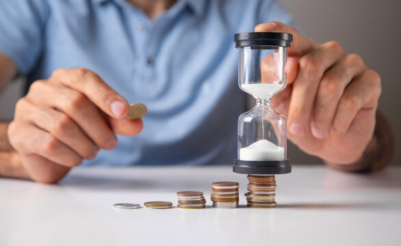 Man showing hourglass with a coins.