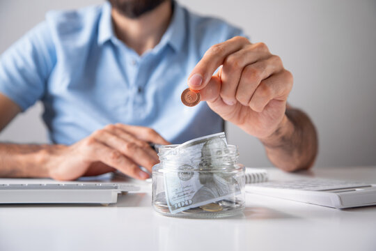 Man putting coin on jar. Finance