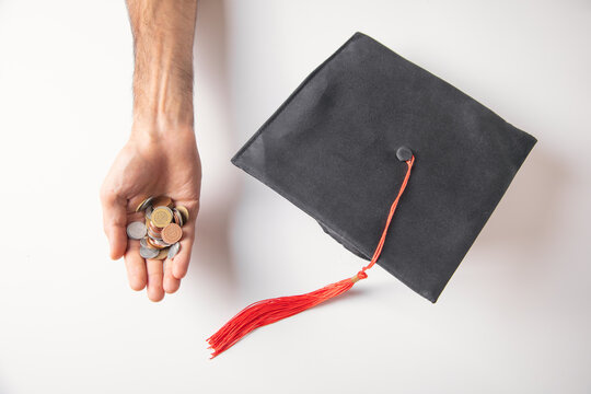 Man showing Graduation Cap with a coins.