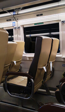 Interior view of a passenger train carriage featuring rows of upholstered seats, a large window, overhead fixtures, and a clean modern transportation cabin.