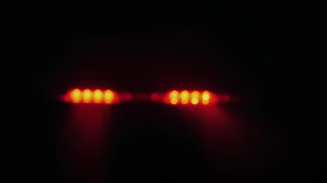 Police emergency strobe lights flashing blue and red in dark foggy night background.