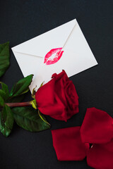 Romantic letter with kiss mark and red rose on dark background © ir1ska