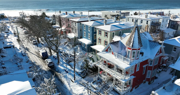 Aerial view of historic Victorian houses covered in snow along a quiet street in Cape May, New Jersey, United States.