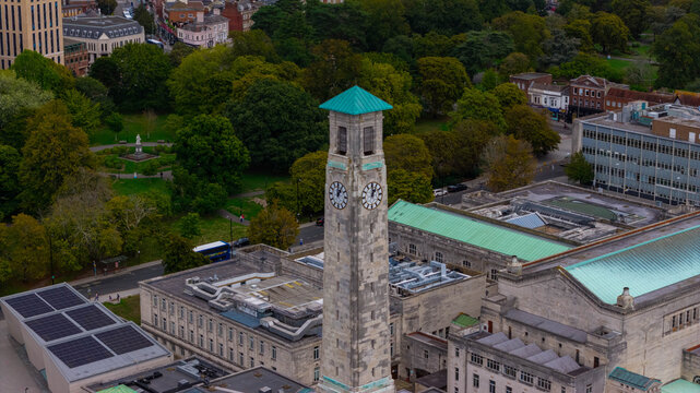 Aerial view of the historic clock tower of the Southampton Civic Centre surrounded by lush parkland and urban architecture in Southampton, England, United Kingdom.