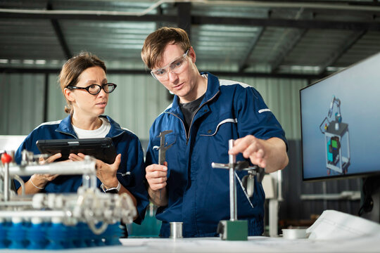 Engineers Examining Mechanical Component in Manufacturing Factory