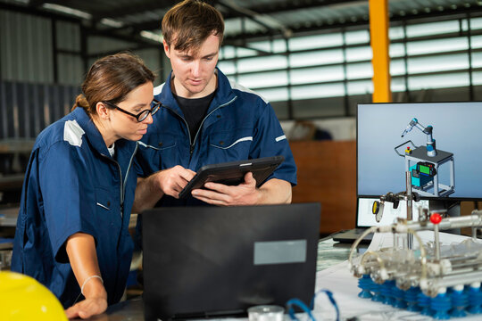 Industrial Engineers Inspecting Machine Component in Manufacturing Factory