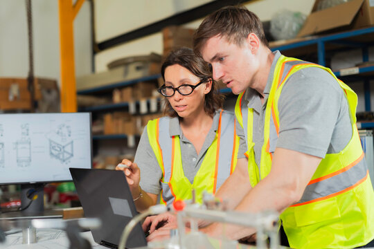 Factory Engineers Analyzing Precision Component During Industrial Inspection