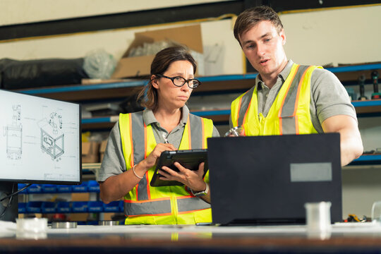 Manufacturing Engineers Examining Mechanical Part in Factory Workshop