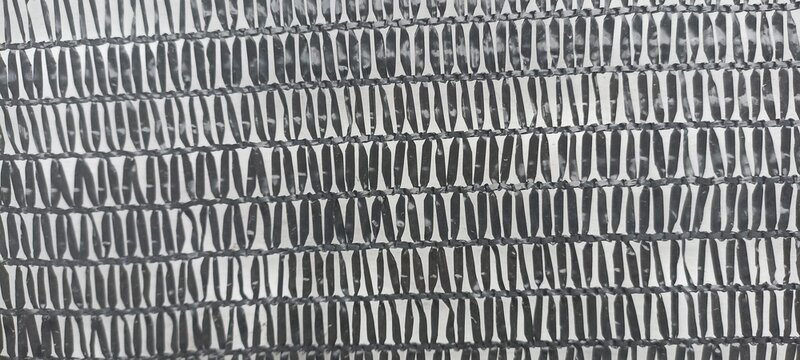 Black agricultural shade net mesh texture pattern close-up, ideal for garden shading, greenhouse canopy backgrounds, and industrial material stock assets