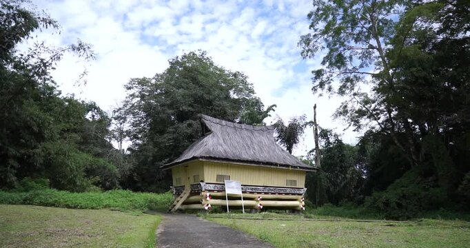 A traditional wooden stilt house built without nails serves as an authentic architectural representation of the dwelling for a royal commander's family within the Simalungun Kingdom compound.