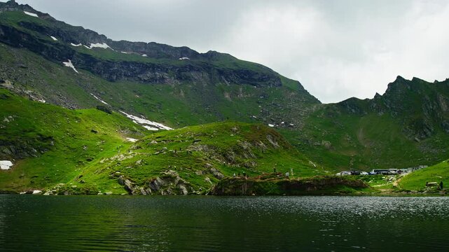 Expansive Balea Lake Beneath Snowy Fagaras Slopes