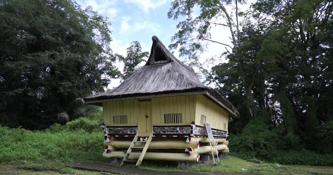 A traditional wooden stilt house built without nails serves as an authentic architectural representation of the dwelling for a royal commander's family within the Simalungun Kingdom compound.