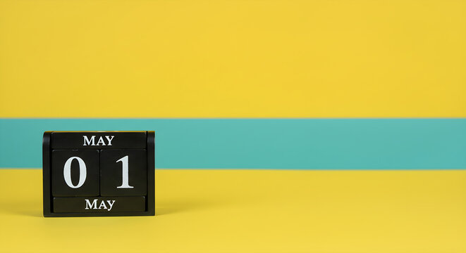 Minimalist Black Block Calendar Displaying First of May Date Isolated on a Bright Yellow and Turquoise Background for Spring Holiday Celebration