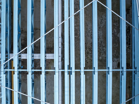 Aerial view of the structural steel framework of an industrial building under construction with parallel girders and metal beams in Melbourne, VIC, Australia.