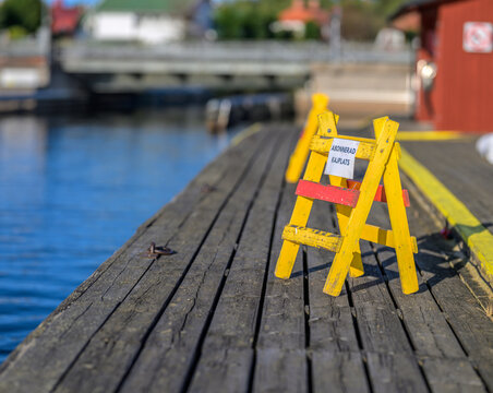 Yellow barrier sign marking reserved marina dock space.