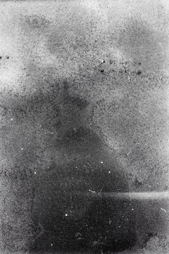 Blank grained film strip texture background with heavy grain, dust and light leak. Old expired soviet moldy photographic film scan. Black and white.