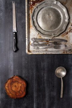 Old various kitchen utensils on black chalkboard background. Food themed flat lay.