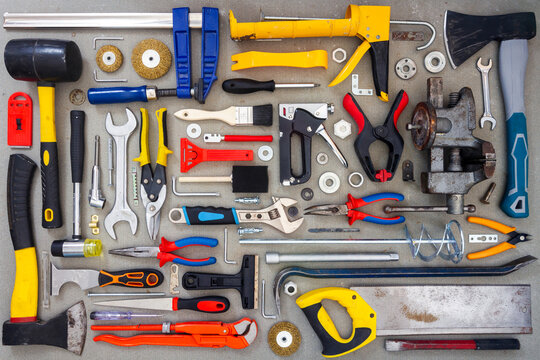 Flat lay of old and new hand tools on concrete background. Large collection of various tools and bits arranged on concrete.
