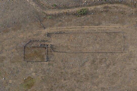 Aerial view of a rustic wooden livestock corral set in a dry, arid landscape with sparse vegetation in Golden, Colorado, United States.