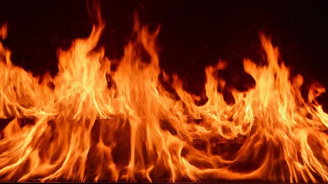Dynamic blazing inferno flames rising against a dark background with intense heat and light effects