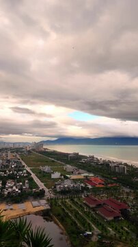 Pan view of Da Nang coastline and Son Tra Peninsula under dramatic cloudy sky during day in Da Nang, Vietnam