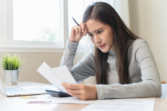 Financial owe, hand of asian woman sitting, holding credit card, stressed by calculate expense from invoice or bill, no money to pay, mortgage or loan