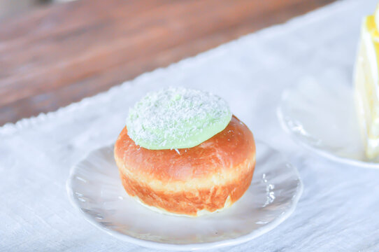 brioche donut or  doughnut or bun with green tea dressing or pandan custard and Coconut flakes topping
