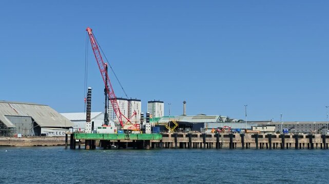 Plymouth Devon England UK. 12.08.2026. A maritime construction project featuring lifting legs on a floating platform, alongside a jetty.