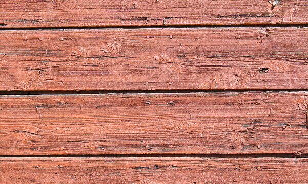 Weathered horizontal wooden planks with faded red paint and detailed natural grain texture background