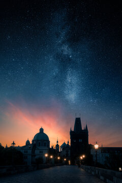 Charles Bridge and Old Town Bridge Tower under the Milky Way and starry night sky at twilight in Prague, Czech Republic