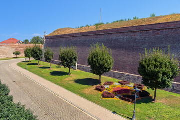 Fototapeta premium Landscaped walkway beside the massive brick walls of Alba Carolina Citadel in Alba Iulia Romania