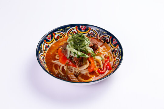 Laghman noodle soup with beef and vegetables in patterned bowl