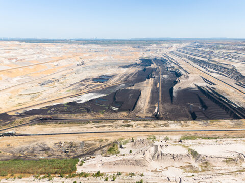 Aerial view of the Hambach open pit mine showing massive lignite coal excavation layers, industrial conveyor belts, and vast earthworks in Elsdorf, North Rhine-Westphalia, Germany.