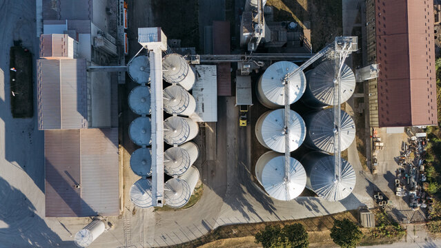Aerial view of the industrial grain silo facility with large metal storage tanks and concrete buildings in Sremska Mitrovica, Vojvodina, Serbia.