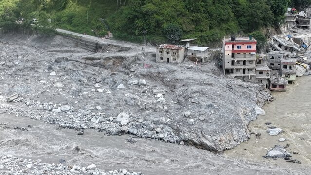 Aerial view of landslide damage and debris affecting buildings along the riverbank, Betrawoti Bazaar, Bagmati Province, Nepal.