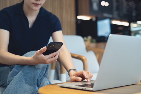 Woman using mobile phone and laptop remote working at coffee shop, freelance lifestyle, online business concept