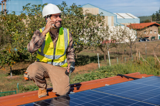 Solar engineer communicating on phone installing renewable energy panels
