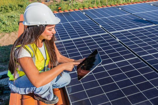 Female solar engineer checking panels on a rooftop