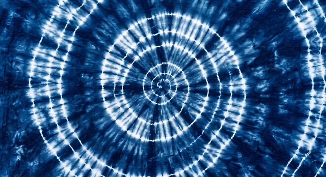 Blue and white tie-dye spiral pattern fabric texture background with swirling indigo dye