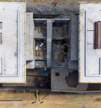 Aerial view of a construction site featuring concrete foundations and staircases with workers on the ground Bursa, Bursa, Turkiye.