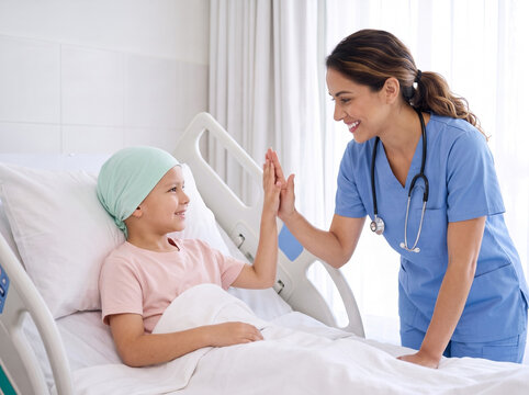 female hispanic doctor in scrubs giving cheerful high five to child patient in hospital bed during cancer recovery for healthcare campaign ad