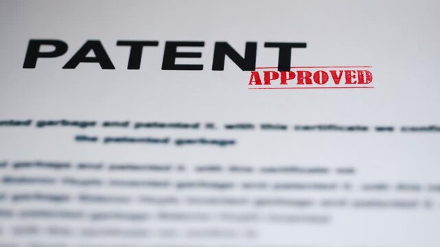 Patent document is approved by a hand with a stamp, signifying successful intellectual property registration and innovation protection.