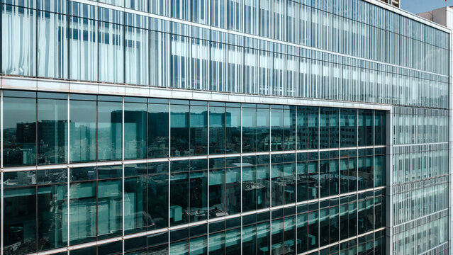 Aerial view of a modern glass-facade office building with reflective windows and geometric architectural details in India.