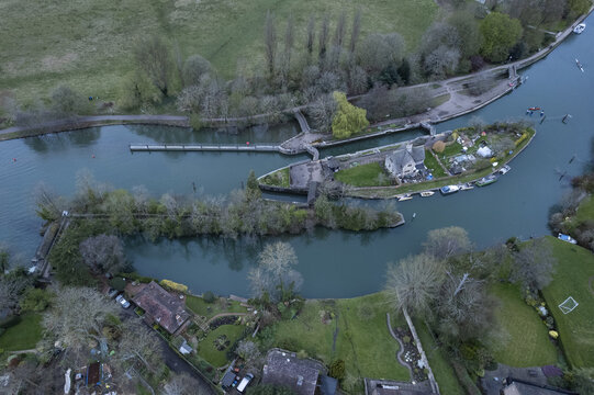 Aerial view of Iffley Lock on the River Thames, featuring the historic lock gates, surrounding lush green banks, and residential properties in Oxford, England, United Kingdom.
