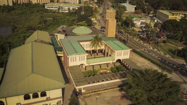 Aerial view of the University of Lagos mosque with its distinctive minaret and green dome, surrounded by lush trees and campus buildings in Lagos, Lagos, Nigeria.