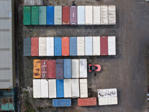 Melbourne, Australia - 25 September 2026: Aerial view of rows of colorful shipping containers arranged in a storage yard with a forklift operating nearby.