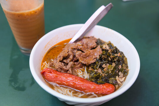 Bowl of noodle soup with beef and sausage
