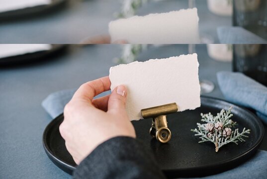 A woman's hand placing a blank deckle-edge place card mockup with a brass clip on an elegant table setting
