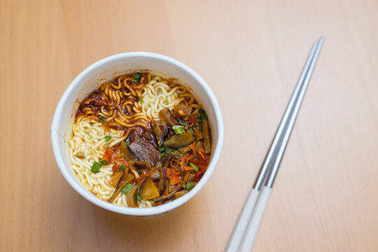 Delicious bowl of noodle soup with chopsticks on table