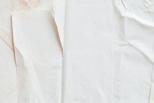 Close up of crumpled white paper with sepia stains and soft shadows